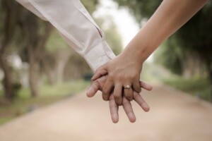 two hands holding eachother with an engagement ring