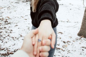 someone leading a person with an engagement ring